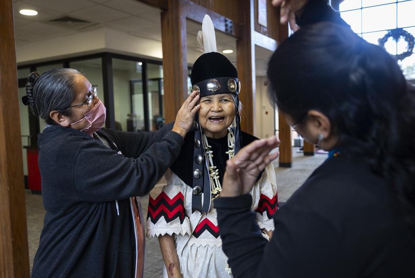 Myra Battise helps newly elected second chief Millie Thompson Williams with her official regalia after a press conference on Monday, January 3, 2023. Battise nominated Williams for the leadership role. Williams is the first female elected as a chief in the tribe’s history.