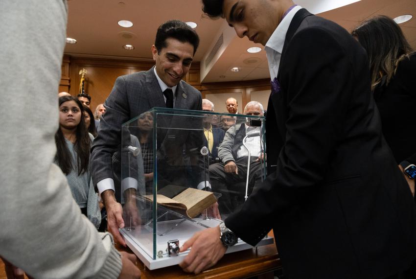 State Rep. Salman Bhojani, D-HD92, and his son carefully move the Qu'ran that he had sworn in on while meeting with supporters at the state Capitol in Austin on Jan. 10, 2022.