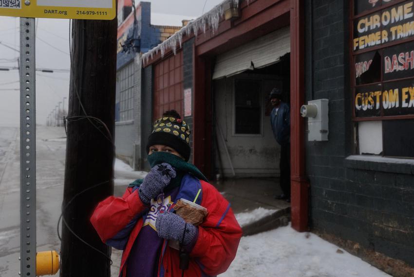 Holly Phillips, an employee at 7-Eleven, finally waits for a bus to get home after she was stuck in the store for two nights as the roads iced over and other employees were not able to come in to take over her shift as winter weather moved through Dallas on Feb. 2, 2023.