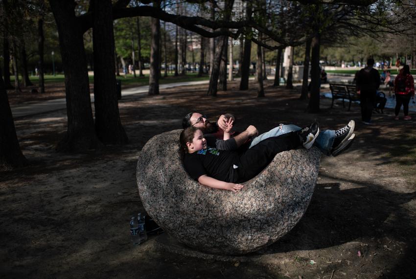 Mario Ochoa and his son Castiel Winchester sit on a rock in Houston’s Hermann Park on Feb. 25. Ochoa said he took his son to a park near his southeast Houston home days after the ITC fire in 2019. “At the time, I didn’t even think about what the contamination would be if he was rolling around playing in the grass,” Ochoa said.