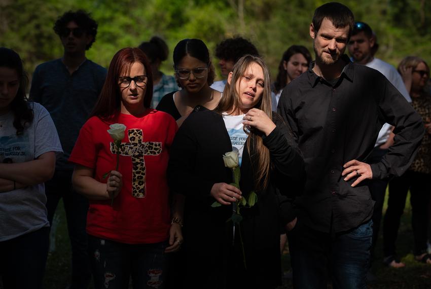 Long time friend Robin Anderson, left, stands alongside mother Amnisty Freelen and her husband Aarin Freelen, during a funeral service for their son Joshua Keith Beasley Jr., 17, on April 1, 2023 at the McCrury Cemetery in Bogota, Texas.