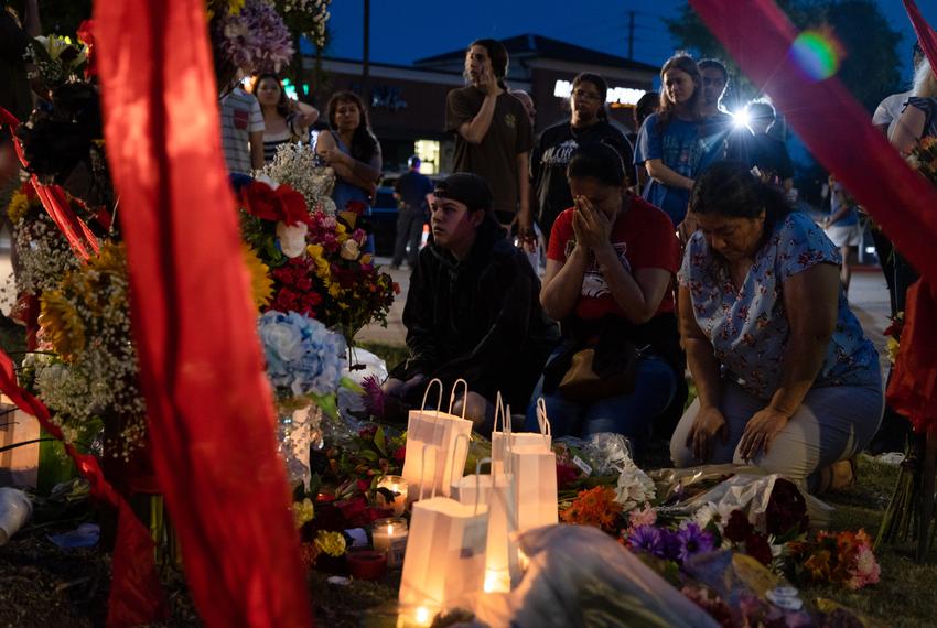 Erica Espinoza, a community member who knew one of the eight victims of the Allen Premium Outlets mall shooting, kneels beside a makeshift memorial for the victims with her sister on May 7, 2023.