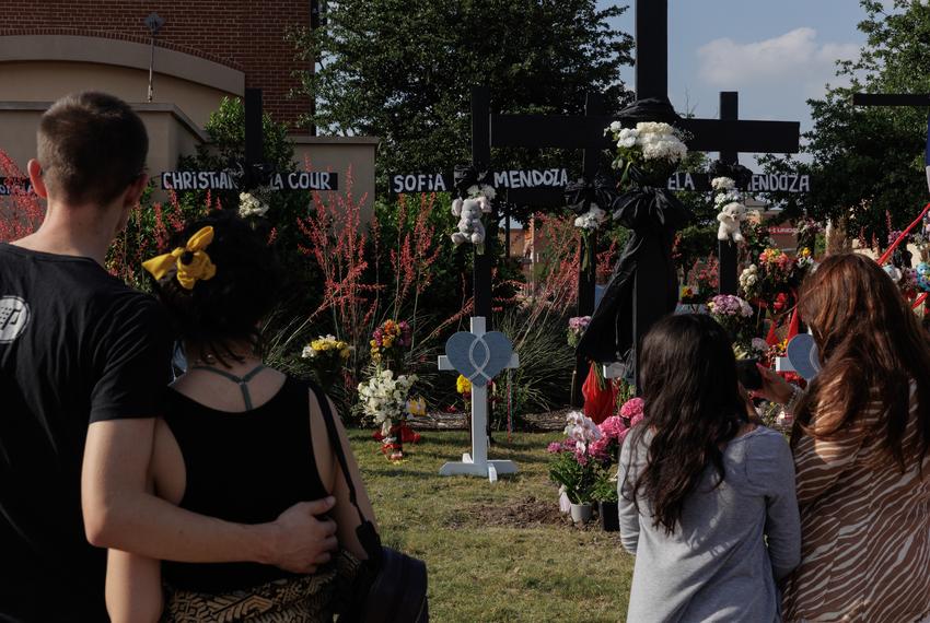 People embrace each other as they mourn the eight people who died in the Allen Premium Outlets shooting at a memorial in Allen, TX on May 8, 2023.