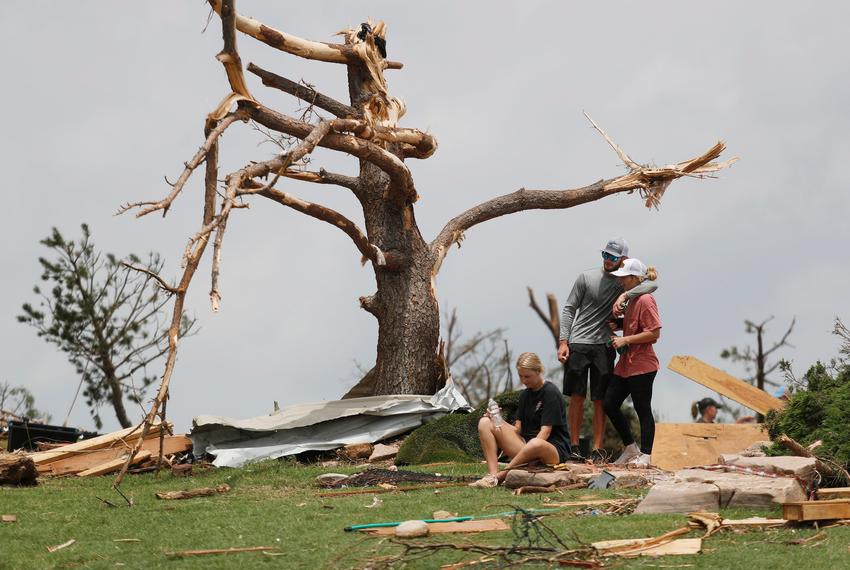 From left, Tyne Marshall sits on the ground next to Brett Homer and Cambrie Marshall, grand daughters of Ken and Mary Marshall, sho survives the tornado. Emergency personnel and Matador townspeople sift through the rubble Thursday morning, June 22, 2013, left after a tornado devastated the small town Wednesday night.