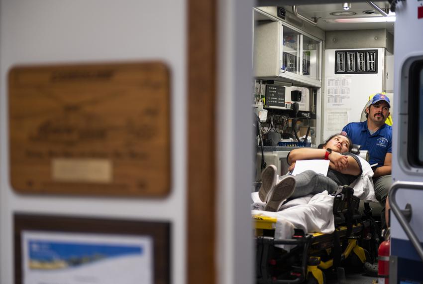 Instructor Doug Anderson works with students in the back of an ambulance while the “patient” Sabrina Rodriguez lays on the gurney during an EMT certification class in the Olton Volunteer Ambulance Association Monday, July 10, 2023, in Olton, Texas. (Justin Rex for The Texas Tribune)