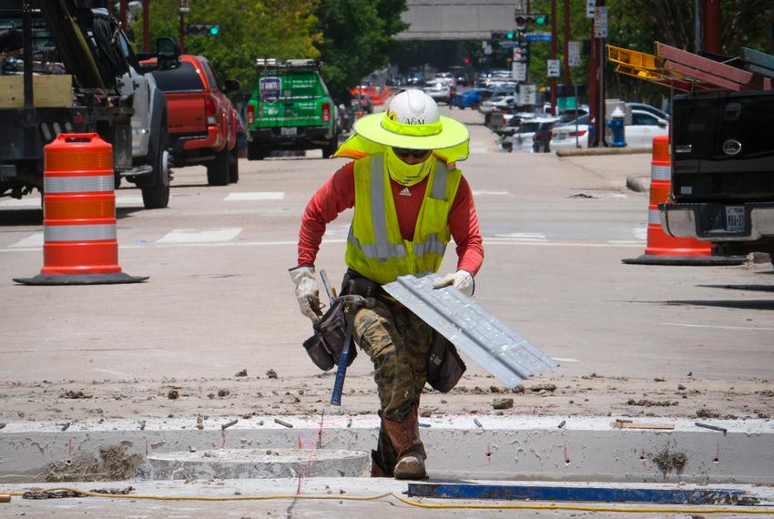 A construction worker carries a piece of metal while working through a heatwave in Houston on Friday, July 14, 2023.                 