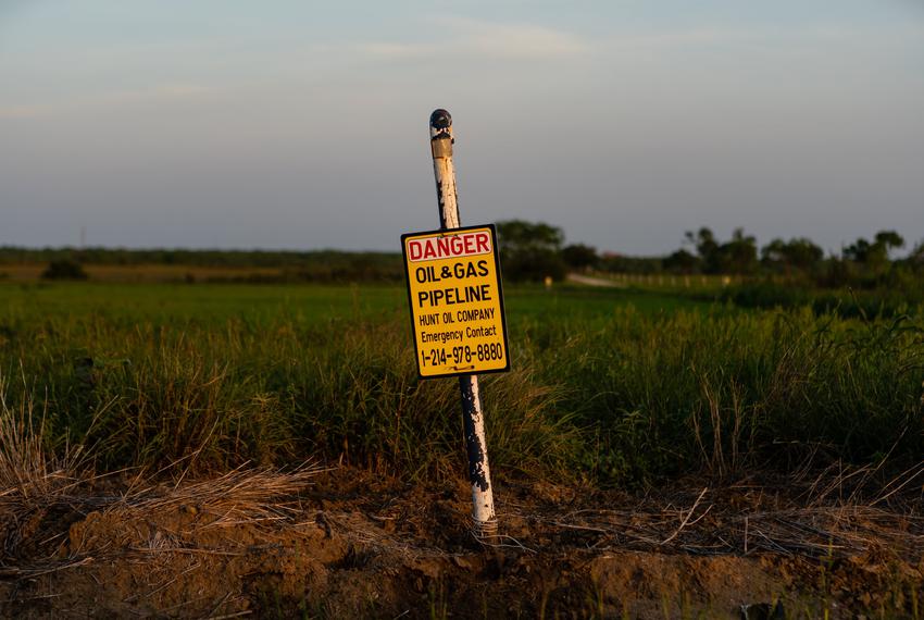 A sign warns passersby of oil and gas pipeline in the area south of San Antonio, TX known as the Eagle Ford Oil Patch.
