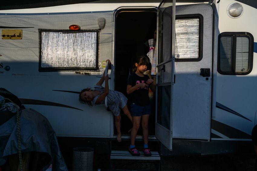 Siblings Samantha, 9, and Alexa Miranda, 4, stand in the doorway of their family’s travel trailer Thursday, Sept. 14, 2023 in West Odessa. The siblings live in the trailer with the four other members of their family, sharing a communal water supply with the other taps in the RV park.