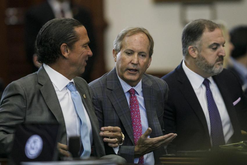 Texas Attorney General Ken Paxton, center, talks with his defense attorney Tony Buzbee, left, before starting the ninth day of his impeachment trial in the Senate Chamber at the Texas Capitol on Friday, Sept. 15, 2023, in Austin, Texas.