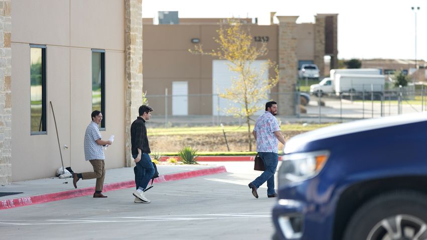 Nick Fuentes (middle) is seen exiting the offices of Pale Horse strategies with Chris Russo, founder and president of Texans for Strong Borders (right) in Fort Worth on Oct. 6, 2023.