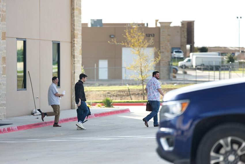 Nick Fuentes (middle) is seen exiting the offices of Pale Horse strategies with Chris Russo, founder and president of Texans for Strong Borders (right) in Fort Worth on Oct. 6, 2023.