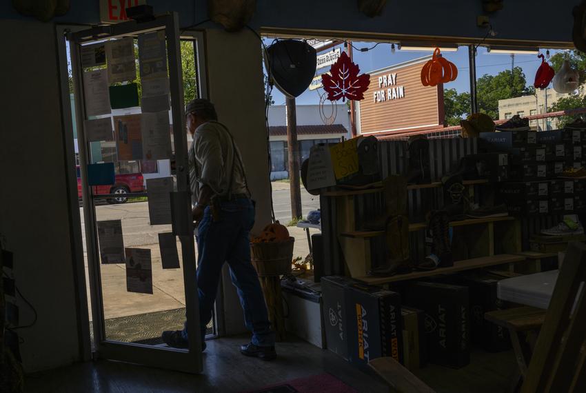 A customer exits the West Bear Creek General Store after making a purchase on Wednesday, Sept. 20, 2023, in Junction. A sign outdoors reads “Pray For Rain” as local residents endure exceptional drought conditions according to the National Integrated Drought Information System.