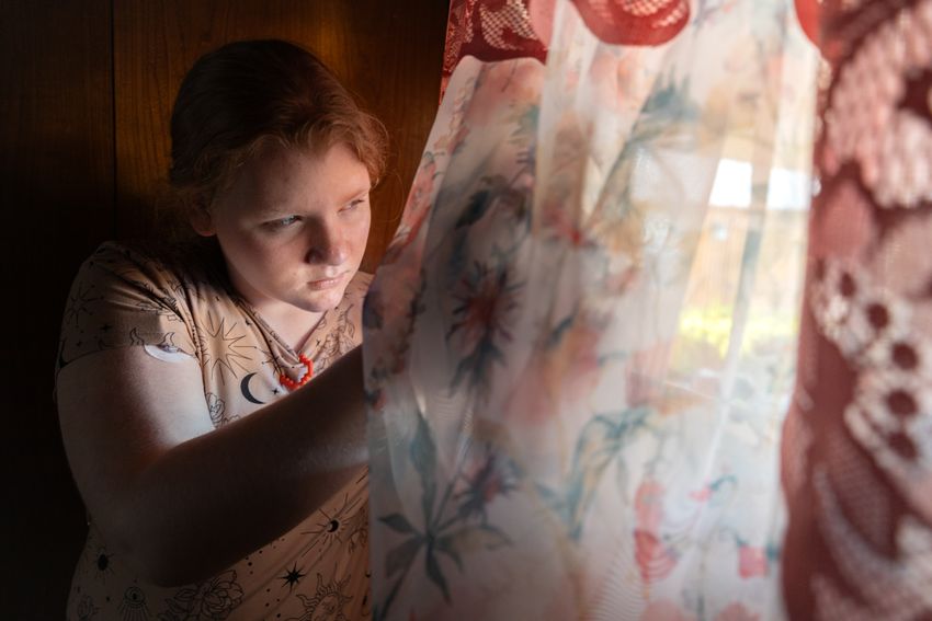 Ashlyn Mosley, 13, peeks through a window in her grandmothers home in Fort Worth, Texas on October 20, 2023.
