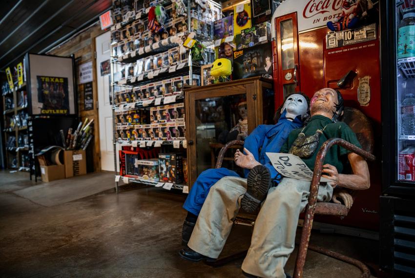 Two life-size horror movie dummies sit in front of a movie prop drink vending machine at We Slaughter BBQ on Oct. 27, 2023 in Bastrop. The roadside rest stop and tourist attraction, now restored, is one of several Central Texas locations where the 1974 film Texas Chainsaw Massacre was filmed.    