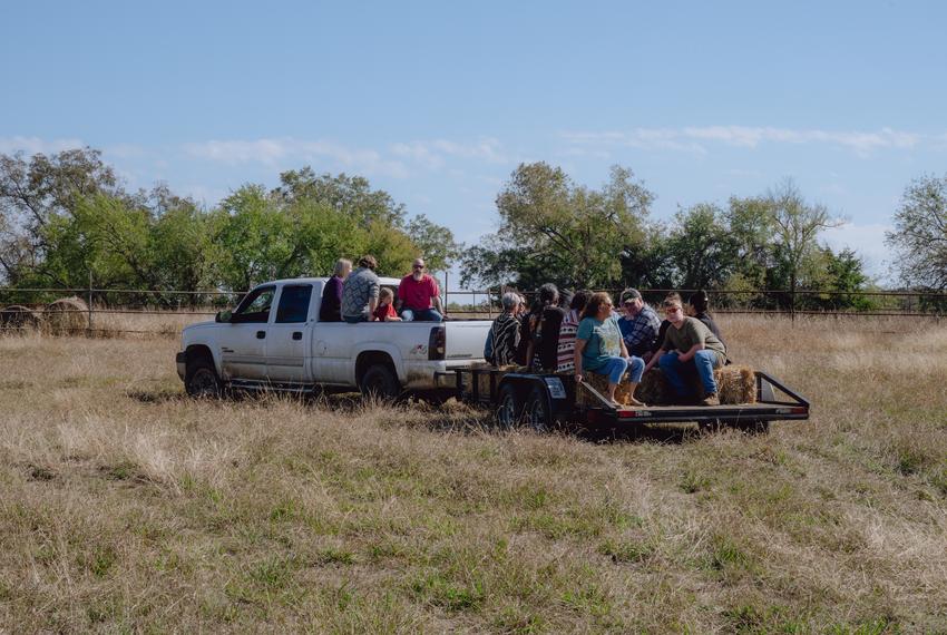 People, including tribe members, load onto a pickup truck and hay ride following a blessing ceremony for three herds of bison gifted to Theda Pogue, affiliated with the Muscogee Creek Nation of Oklahoma, and her family on Saturday, November 4, 2023 at GP Ranch in Sulphur Springs, Texas.