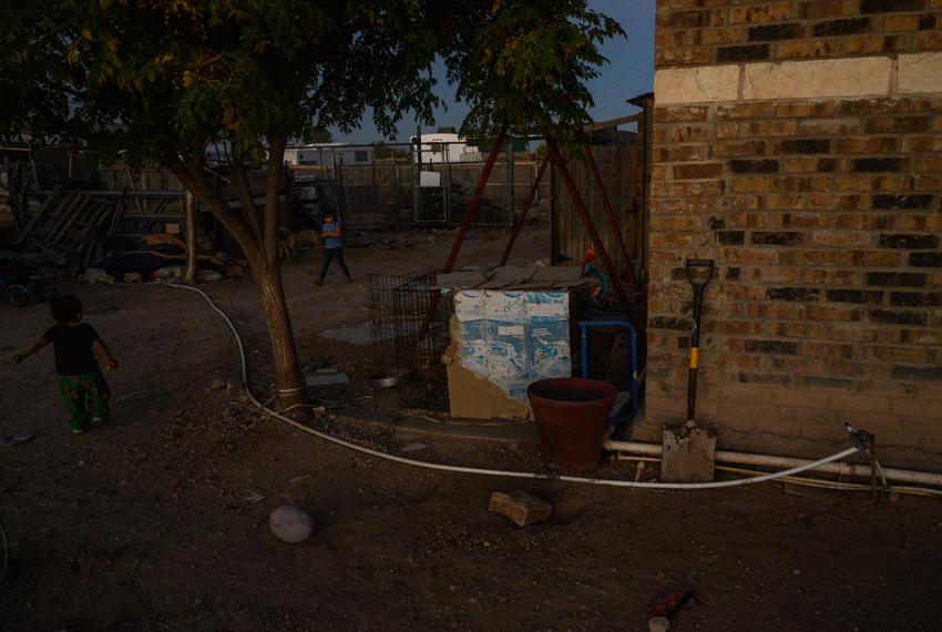 Jesús Sierra’s grandchildren Xavier, 2, left, and Malyna, 5, right, play in the yard of their family’s yard Monday, Nov. 6, 2023, in West Odessa. A small PVC pipe seen nearby  provides water to their parent’s home.