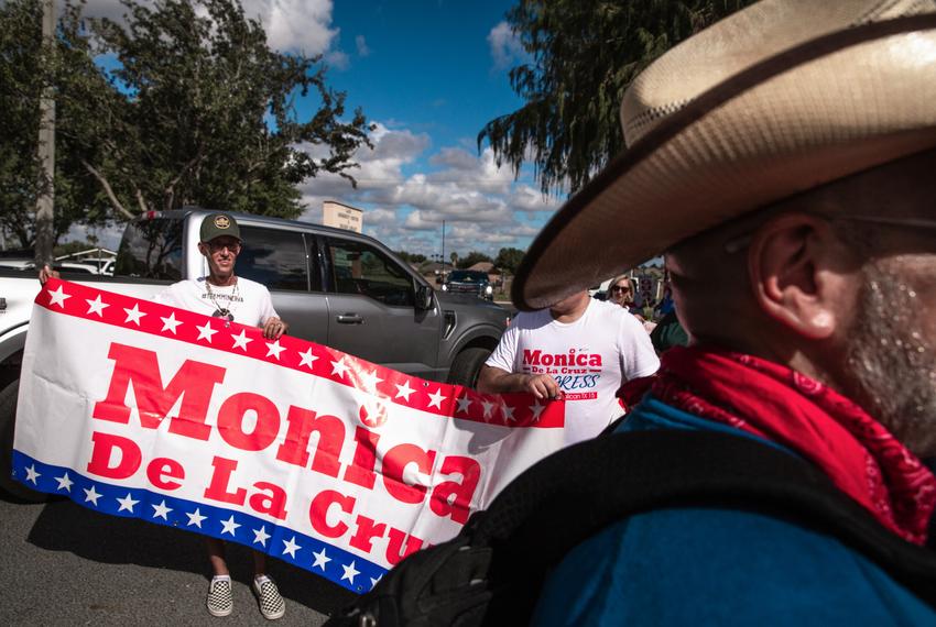 Supporters of Monica De La Cruz hold a campaign banner outside the Lark Community Center in McAllen on Election Day, Nov. 8, 2022.