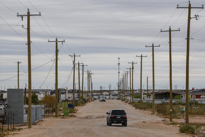 Motorists drive down a caliche road in Knox Village, a mixed neighborhood of permanent homes, residential trailers and recreational vehicles Monday, Nov. 6, 2023, in West Odessa.