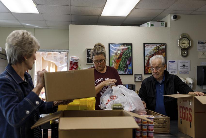 Volunteers from left to right, Evelyn McMillen, Leigh Cox and Victor Surita help to package orders of groceries at El Buen Samaritano food pantry in Austin, Texas on Nov. 14, 2023.
