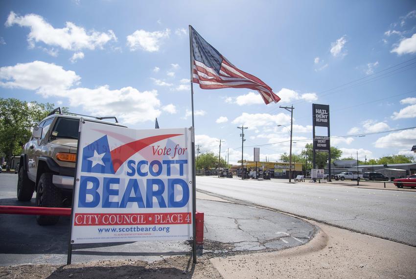An American flag waves in the wind next to a sign for Scott Beard in Abilene, Texas on Thursday, April 27, 2023. (Photo by Emil T. Lippe for Pro Publica)