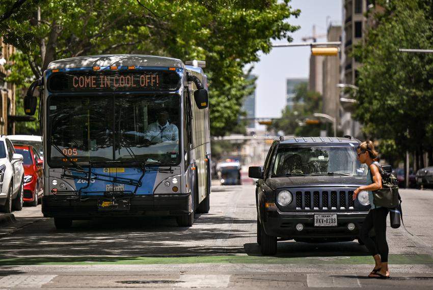 A Metro bus reads “Come in cool off!” as it drives south on Guadalupe Street in Austin on July 22, 2022.