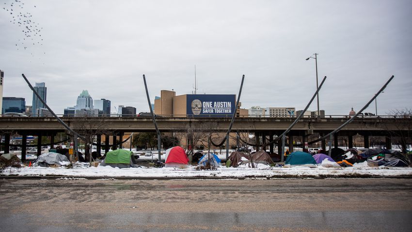 Tents sit along the I-35 frontage road on Feb. 16, 2021 in Austin. A winter storm has caused icy roads and left millions of Texans without water or electricity.