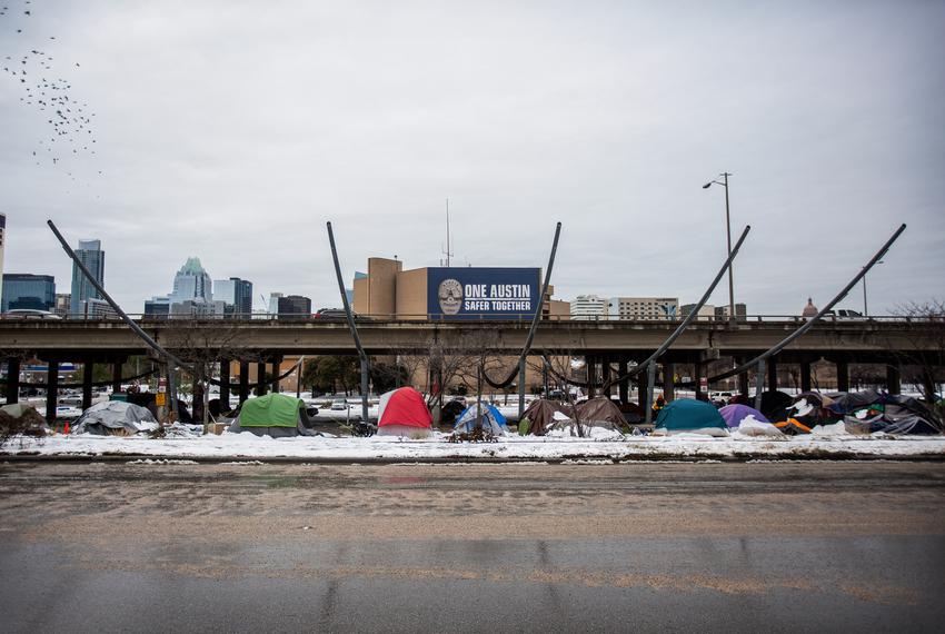 Tents sit along the I-35 frontage road on Feb. 16, 2021 in Austin. A winter storm has caused icy roads and left millions of Texans without water or electricity.