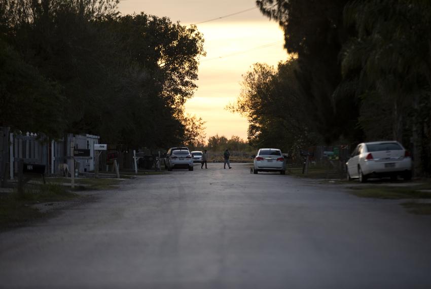 People walk down a road in Donna before nightfall. Dec. 7, 2020.