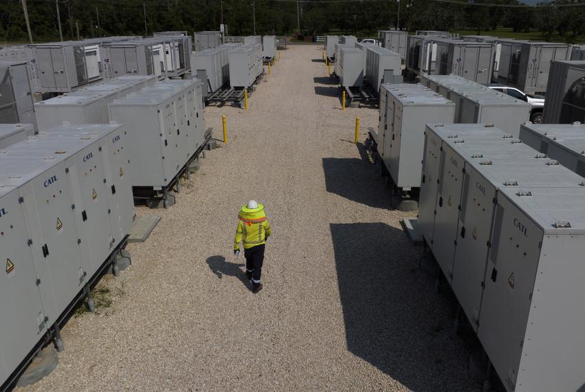 An engineer walks past battery banks and inverters at GlidePath's Byrd Ranch energy storage facility in Sweeny, on May 23, 2023.