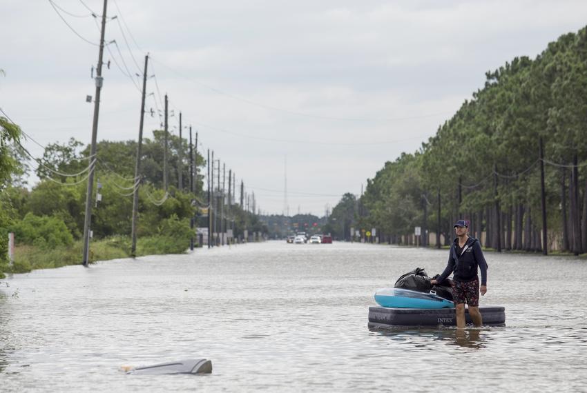 Jeremy Boutor carries personal items from his home on an air mattress in a neighborhood along Eldridge Parkway in Houston on Aug. 30, 2017. The streets were flooded by waters released from the Addicks Reservoir and from Hurricane Harvey.