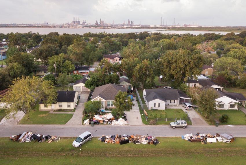 Motiva, the largest refinery inthe United States, in the distance in Port Arthur, Texas Wednesday, September 20, 2017 where piles of flood damaged debris are piled outside of homes. (Photo by Michael Stravato)
