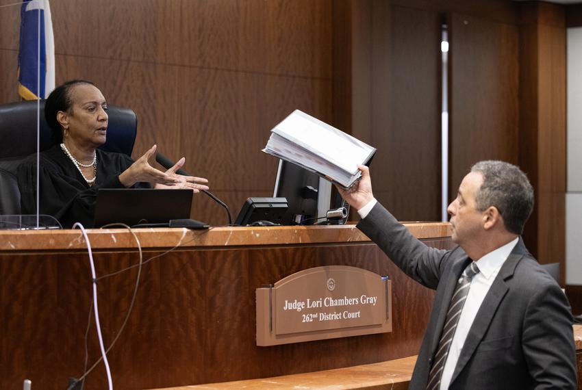 Joshua Reiss, a division chief with the Harris County District Attorney's Office, at right, hands Judge Lori Chambers Gray a copy of Syed Rabbani’s original trail transcript during a hearing for Rabbani at the Harris County Criminal Justice Center, Tuesday, Nov. 14, 2023, in Houston. Rabbani was issued the death sentence in 1988 after a jury found Rabbani guilty of killing a fellow Bangladeshi immigrant, 28-year-old Mohammed Hasan, at a Houston convenience store. (Antranik Tavitian / Houston Landing)