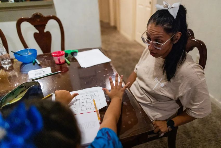 Laura Ortega helps her eight-year-old daughter study after school Sept. 27, 2023, at their east Houston home.