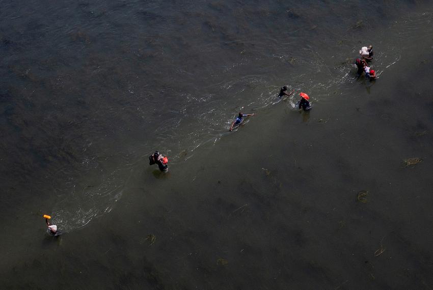 Migrants seeking refuge in the U.S. cross the Rio Grande back into Ciudad Acuña, Coahuila, Mexico as others return to the U.S. carrying food supplies near Del Rio on Sept. 19, 2021.