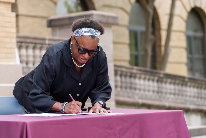 Kathleen McElroy signs her appointment letter during a ceremony at Texas A&M University, on June 13, 2023.