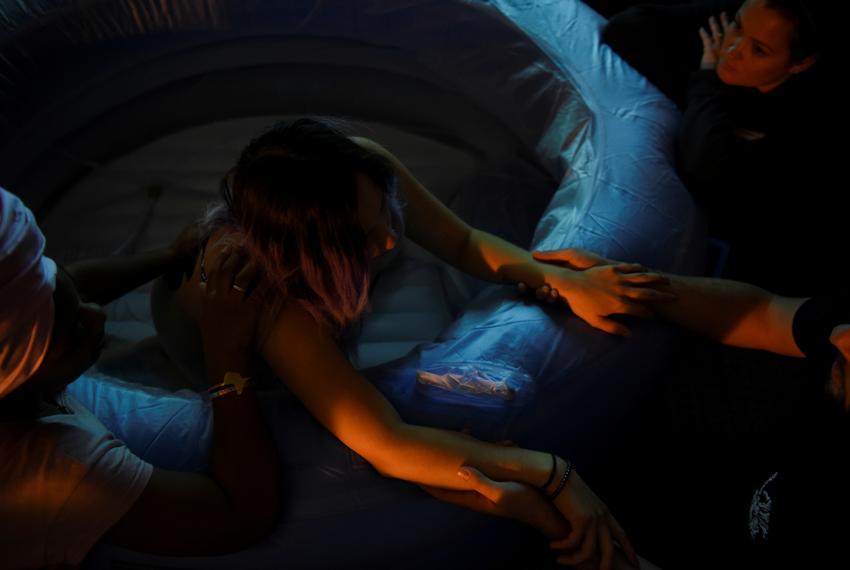 Nancy Pedroza, 27, who is pregnant, is supported by Nichollette Jones, her doula, and Ryan Morgan, 30, her partner and father to their unborn child, as she experiences contractions in a birthing tub, while laboring at the home of Pedroza's licensed midwife, Susan Taylor, where Pedroza plans to give birth, during the coronavirus disease (COVID-19) outbreak, in Fort Worth, Texas,?U.S.,?April 7, 2020.