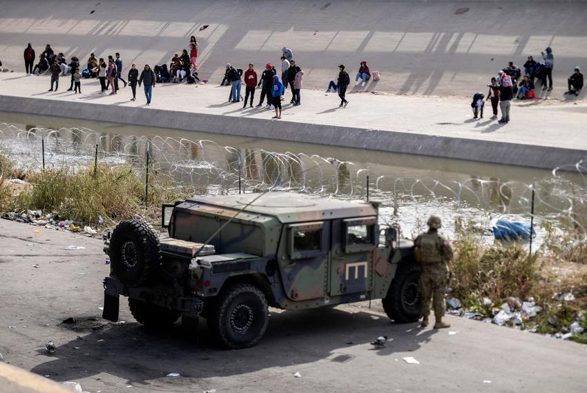Texas National Guard and Texas DPS officers position themselves on the banks of the Rio Grande on Tuesday, Dec. 20, 2022, in El Paso. Over 400 personnel have been sent to this border sector by Governor Abbott after El Paso city officials declared a state of emergency.