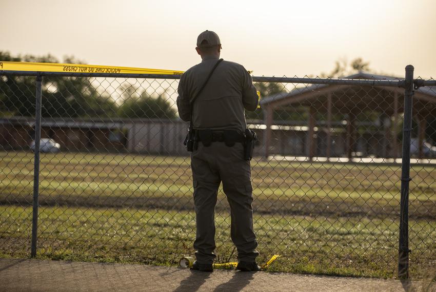 A Texas Highway Patrol trooper behind Robb Elementary School in Uvalde May 25, 2022, one day after a gunman killed 19 students and two teachers.