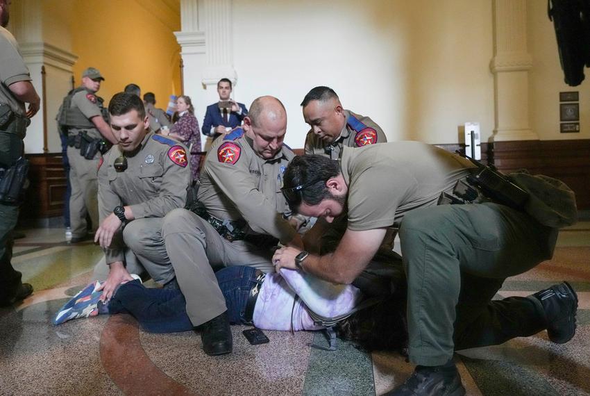 LGBTQ rights activist Adri Pérez is detained by Department of Public Safety troopers as activists protest SB 14 outside of the House of Representatives gallery at the Capitol on May 2, 2023.
