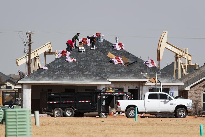 A roofing crew begins to shingle a home under construction in the new Pavilion Park housing development on March 14, 2022 in north Midland.