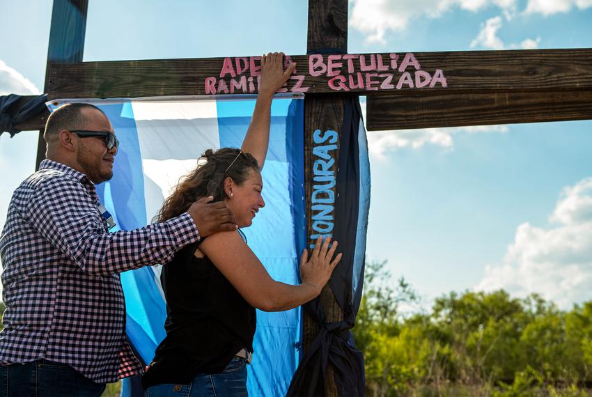 Gloria Quezada, right, holds on to a cross with her daughter's name, Adela Betulia Ramírez Quezada, at the memorial in San Antonio.