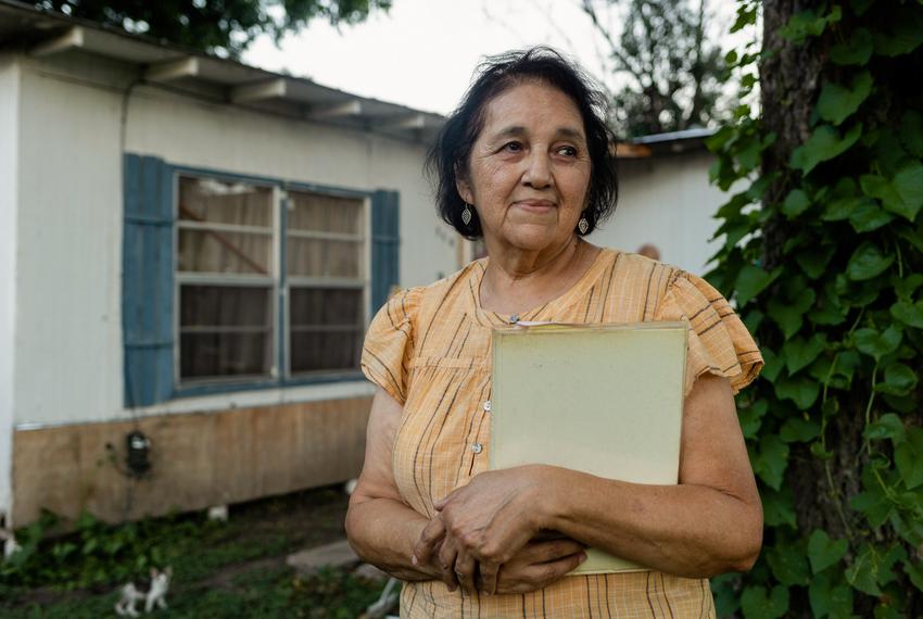 Rebecca Ciprian-Moreno, a retired Spanish teacher who took part in the 1970 Uvalde school boycott, holds a school yearbook from the 1970s outside the home where she was born in Uvalde.