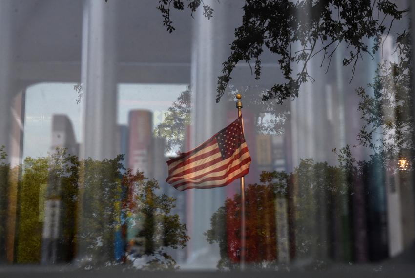 A reflection of an American flag is visible as a Little Free Library, which was designed to look like a prison, invites residents to take books that the library says have been challenged by schools across the state of Texas, in Houston, Texas, U.S. May 3, 2023.   REUTERS/Callaghan O'Hare - RC25R0AT2JN3