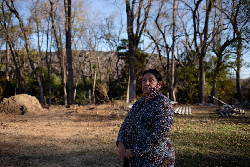 Cecilia Del Toro Garcia stands in her backyard, where Shingle Mountain is visible in the background. Her backyard, which was once a home for Garcia’s garden, is now barren due to the toxic waste dump.
